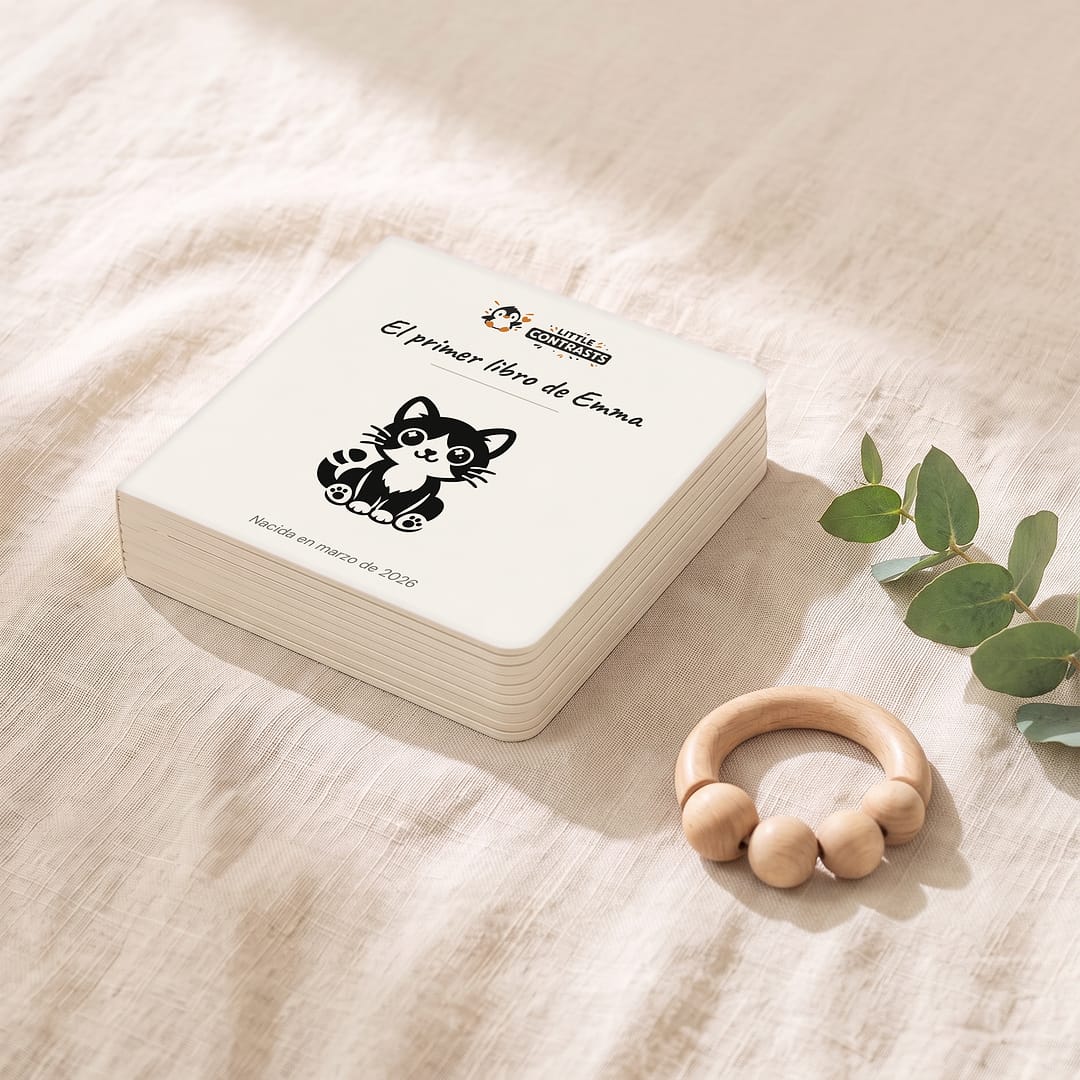 Imagen ilustrativa: el libro personalizado de Emma, cerrado, sobre lino junto a un sonajero de madera